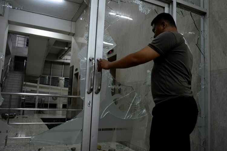 Petugas Keamanan Universitas Negeri Makassar (UNM) Melihat Kondisi Pintu Masuk Kampus Yang Dirusak Bentrok Kawal Putusan MK
