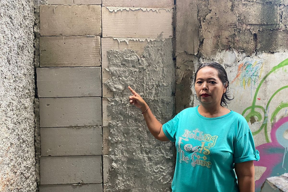 Potret Warga Bernama Puji Rahayu (49) Menunjuk Akses Jalan Depan Rumahnya Ditutup