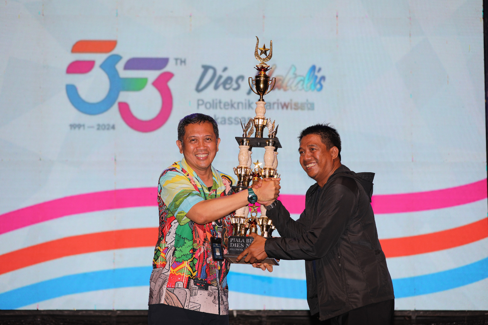 Direktur Poltekpar Makassar Menyerahkan Piala Bergilir Dies Natalis Ke 33 Kepada Ketua Prodi Pengelolaan Konvensi dan Acara Selaku Juara Umum Tahun 2024