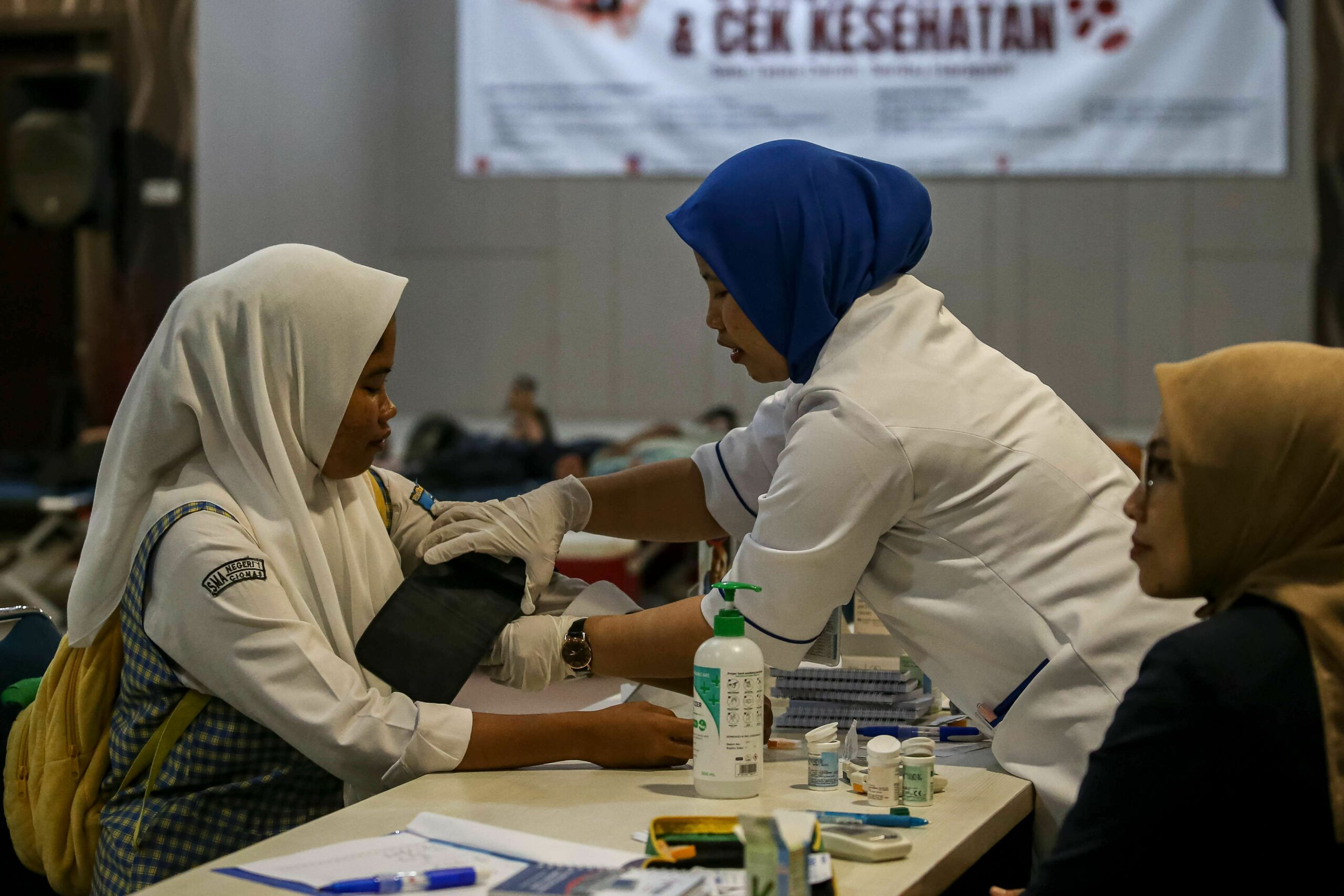 Petugas Kesehatan Saat Memeriksa Tekanan Darah Pelajar