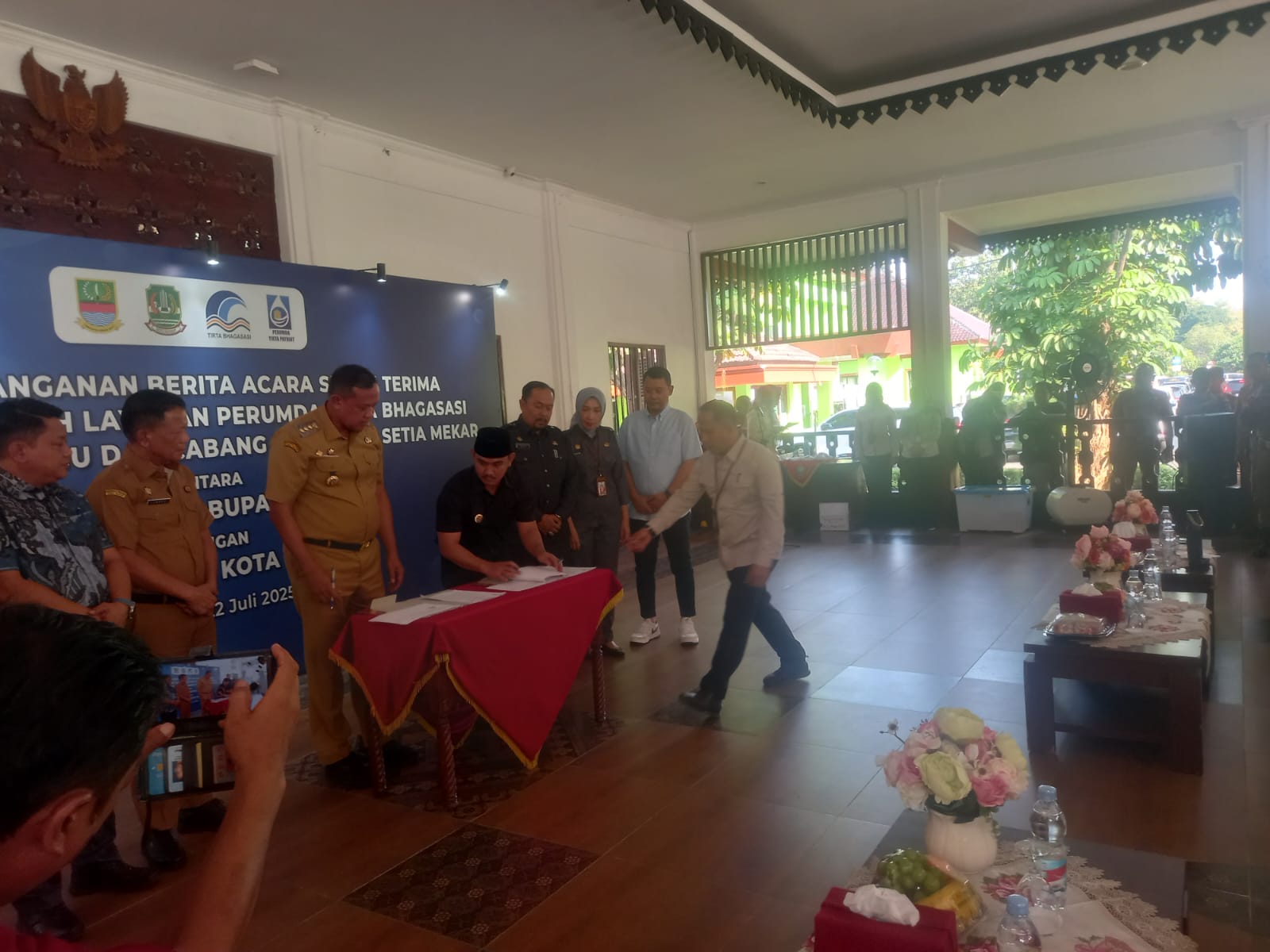 Wali Kota Bekasi, Tri Adhianto dan Bupati Kabupaten Bekasi, Ade Kuswara Saat Menandatangani Berita Acara Serah Terima Aset Serta Wilayah Operasional Perumda Tirta Bhagasasi Cabang Rawa Lumbu dan Cabang Pembantu Setia Mekar
